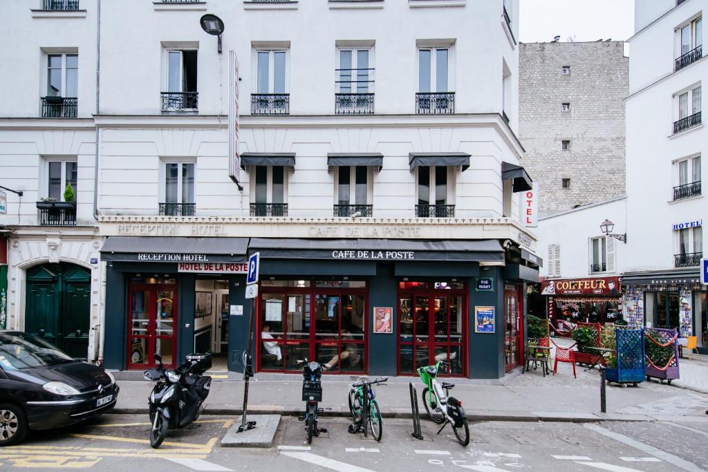 un bâtiment dans une rue de la ville avec des vélos garés à l'extérieur dans l'établissement Hotel De La Poste, à Paris