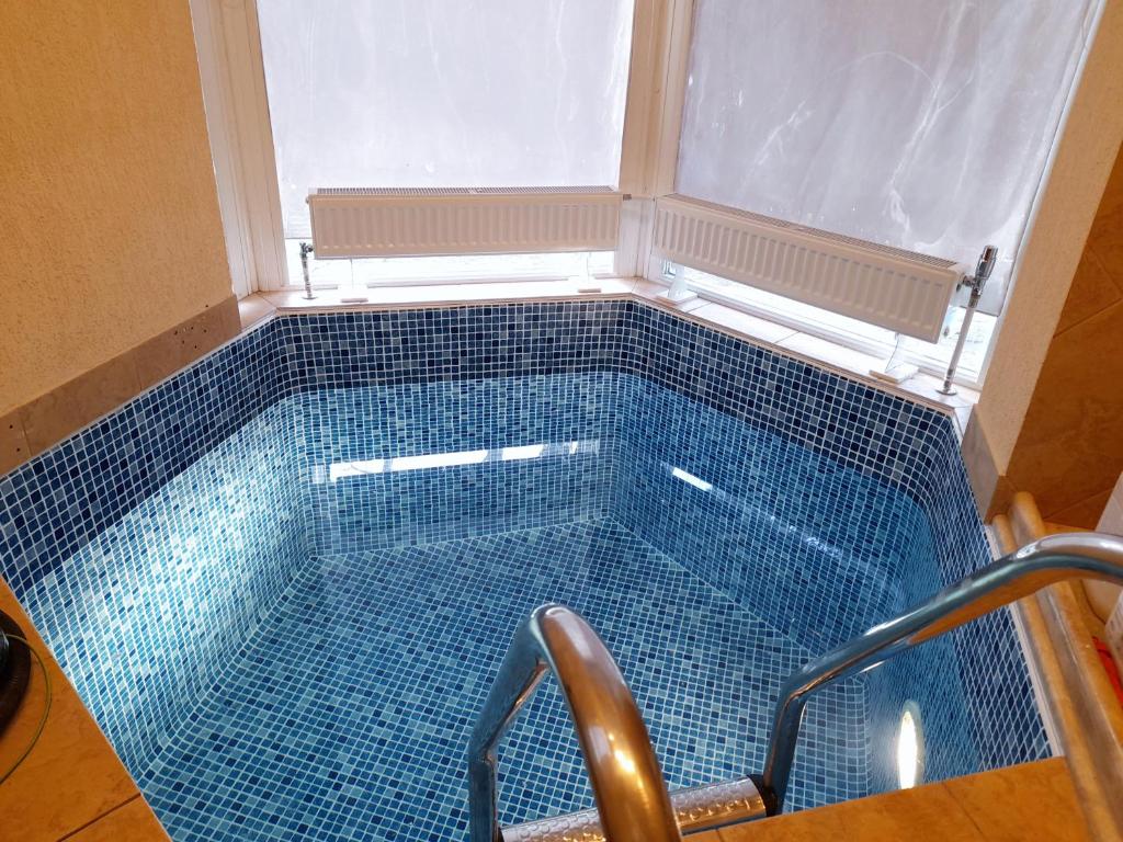 a swimming pool with a blue tiled floor at Apartament Dzintari in Jūrmala