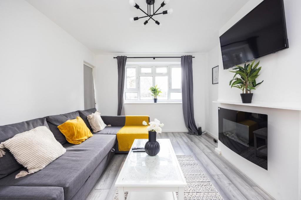 a living room with a couch and a fireplace at Modern 2 Bedroom Apartment Brixton Station in London