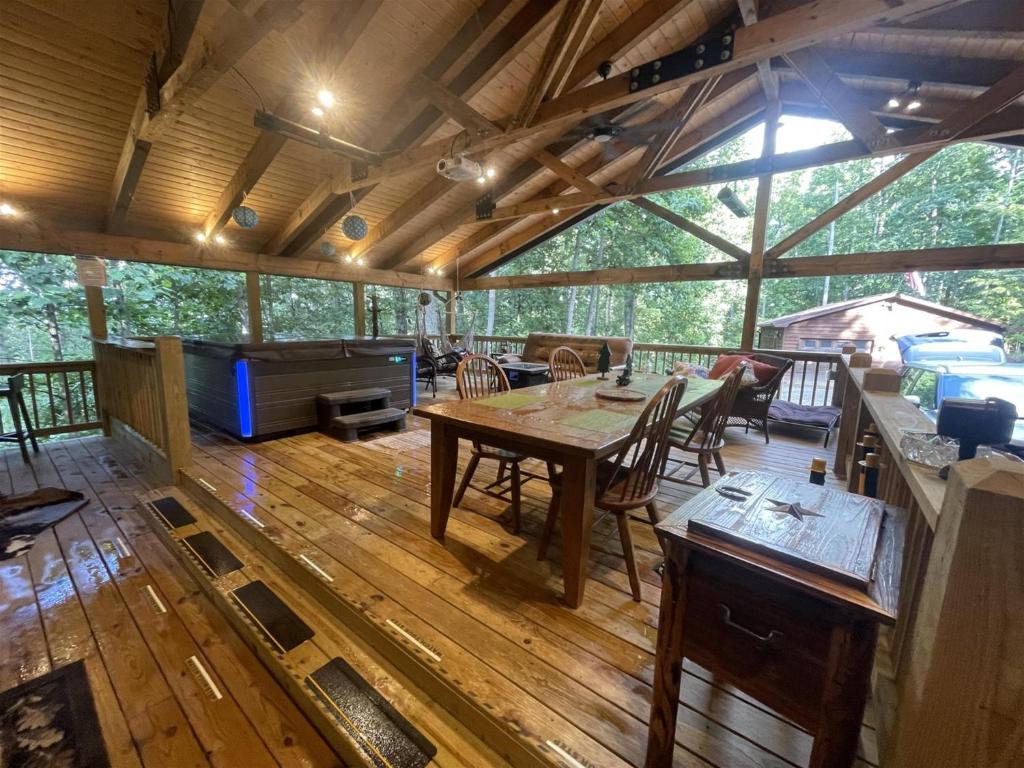 a large screened in porch with a table and chairs at Poplar Ridge Retreat in Blairsville