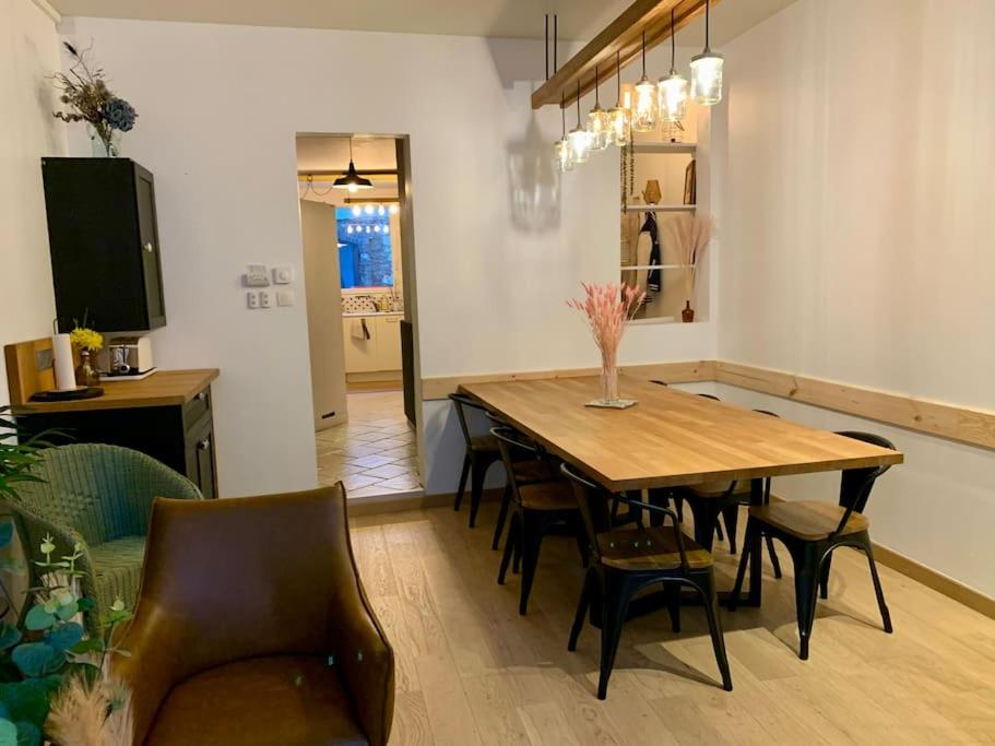 uma sala de jantar com uma mesa de madeira e cadeiras em Au cœur du centre historique ! em Beauvais