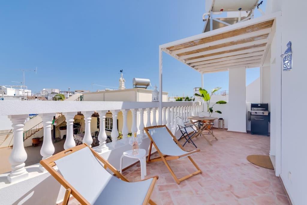 a balcony with chairs and a table on a building at Casa do sol nascente Olhão - Boutique Collection in Olhão