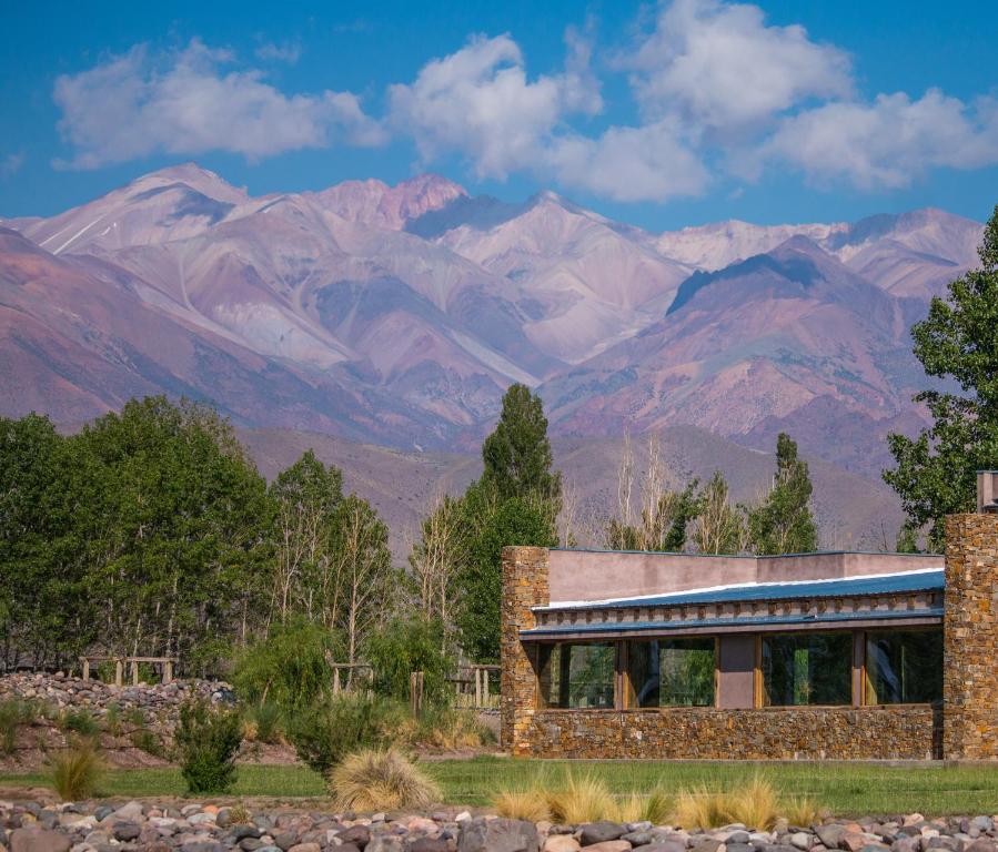a stone house with mountains in the background at Estancia San Alberto Lodge in Uspallata