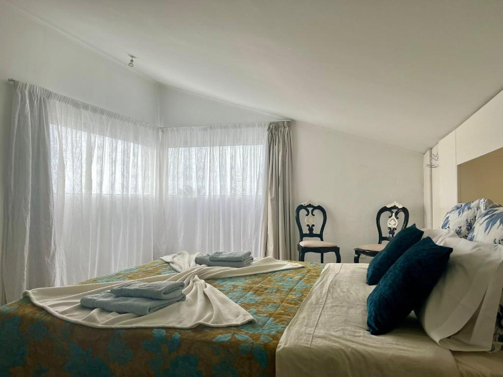 a bedroom with two beds with blue pillows and a window at Casa Caloura Seaside Deluxe Accommodation & Spa in Lagoa