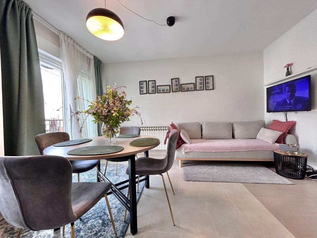 - un salon avec un canapé rose et une table dans l'établissement Apartmani Jagić - Zagreb - Maksimir, à Zagreb