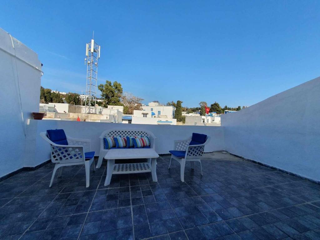 een patio met een tafel en stoelen op een dak bij YoYo House in Sidi Bou Saïd