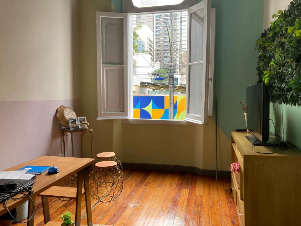 - un salon avec une table et une fenêtre dans l'établissement Pousada Barão de Santa Helena, à Juiz de Fora