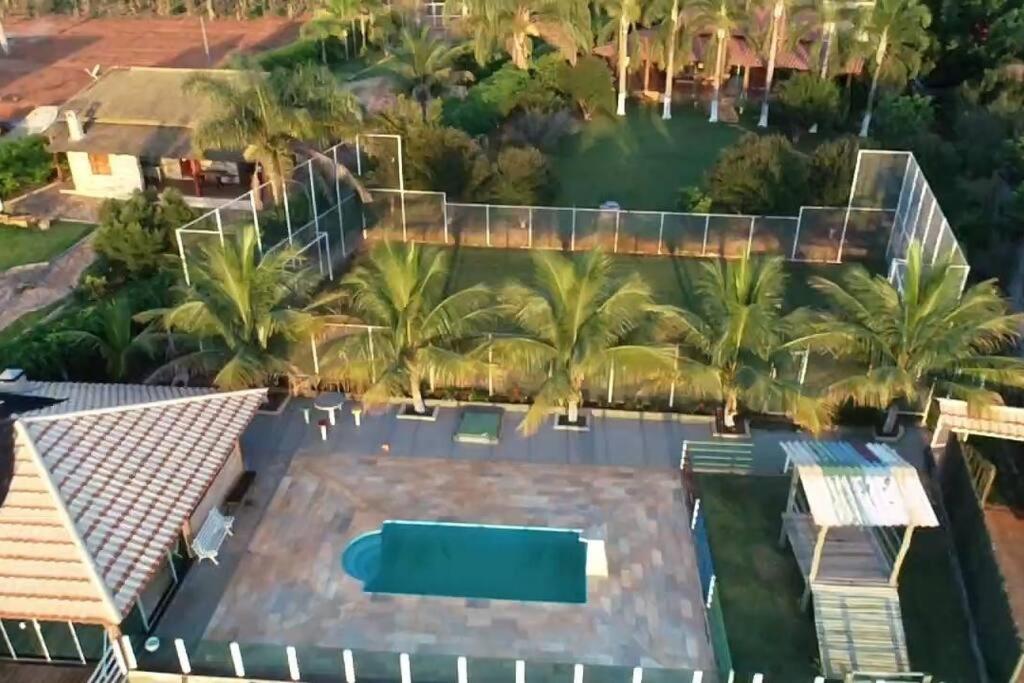 Rancho Encanto de Furnas - Guapé في غوابيه: اطلالة جوية على منزل به مسبح والنخيل