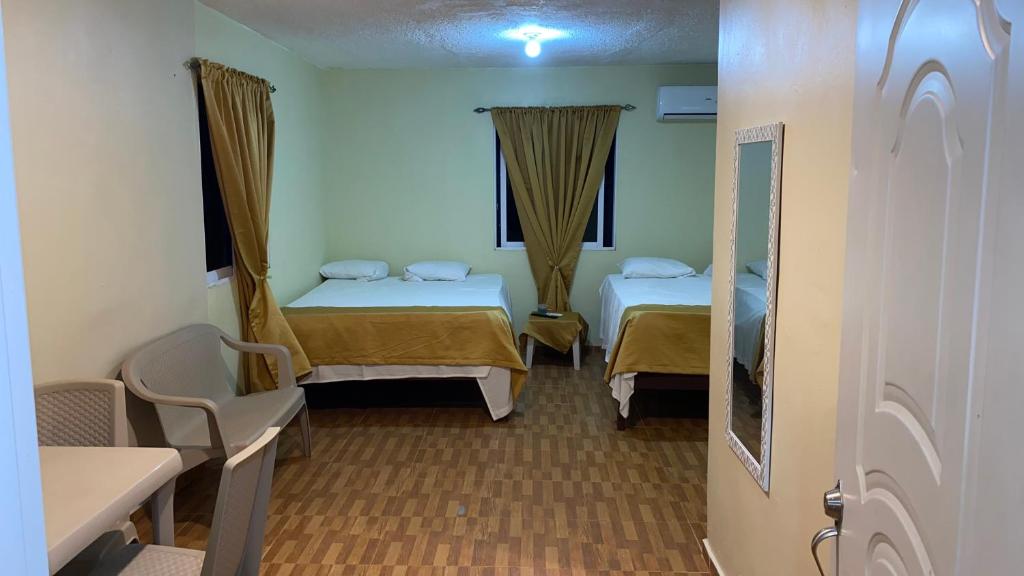 Habitación con 2 camas y ventana en Paraíso de Rojas hotel en Santa Bárbara de Samaná