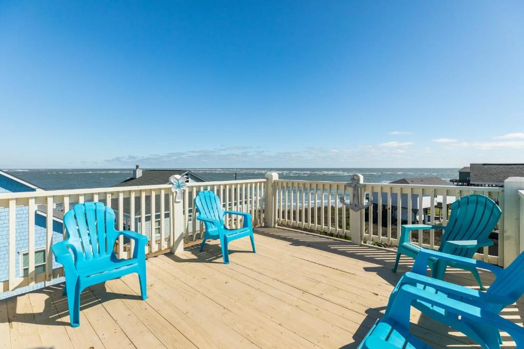 three blue chairs sitting on a deck overlooking the ocean at Amazing 360 Ocean & Bay Water Views in Freeport