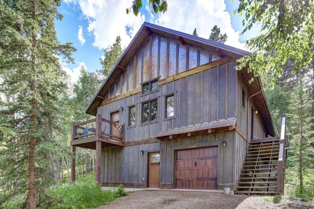 une maison de style grange dans les bois avec un garage dans l'établissement Whiskey Barrel Cabin, à Lead