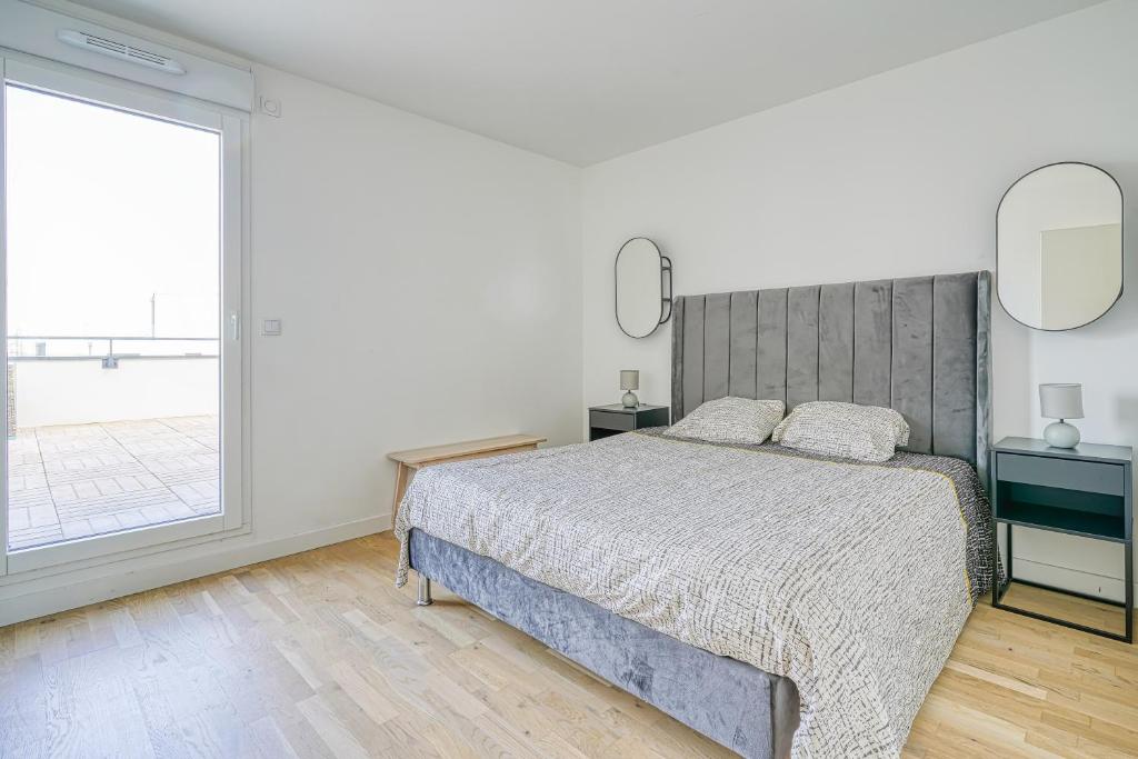 a bedroom with a bed and a large window at Grand appartement avec belle vue Paris in Rueil-Malmaison