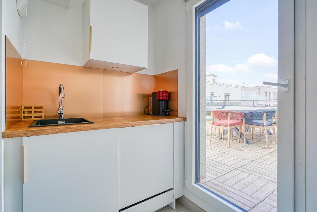 a kitchen with a view of a patio at Grand appartement avec belle vue Paris in Rueil-Malmaison