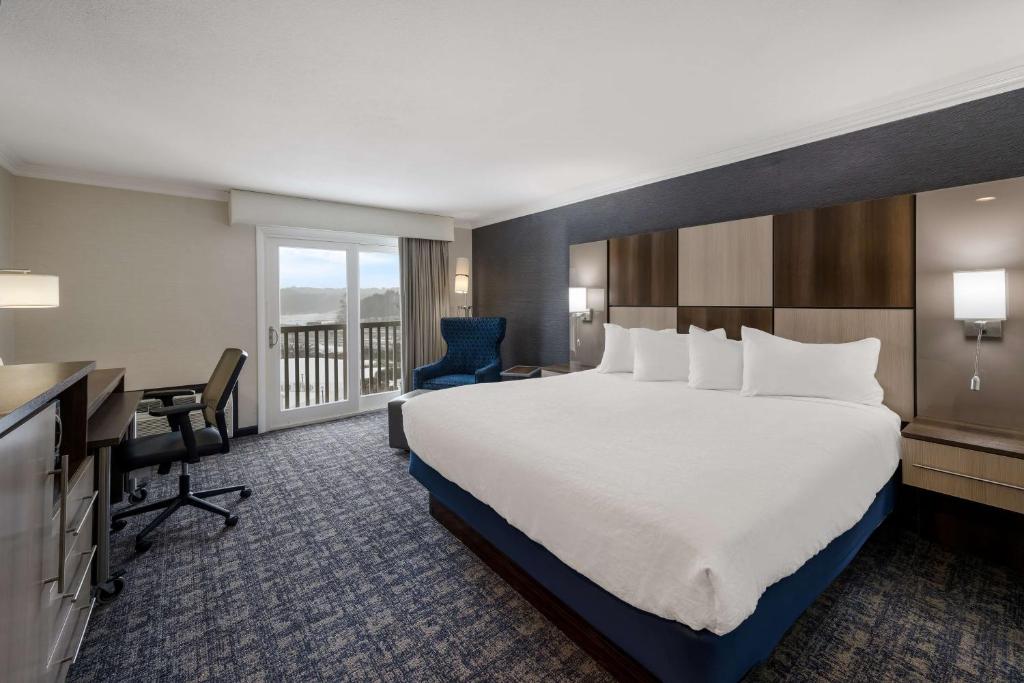 ein Hotelzimmer mit einem großen Bett und einem Schreibtisch in der Unterkunft Best Western - Freeport Inn in Freeport