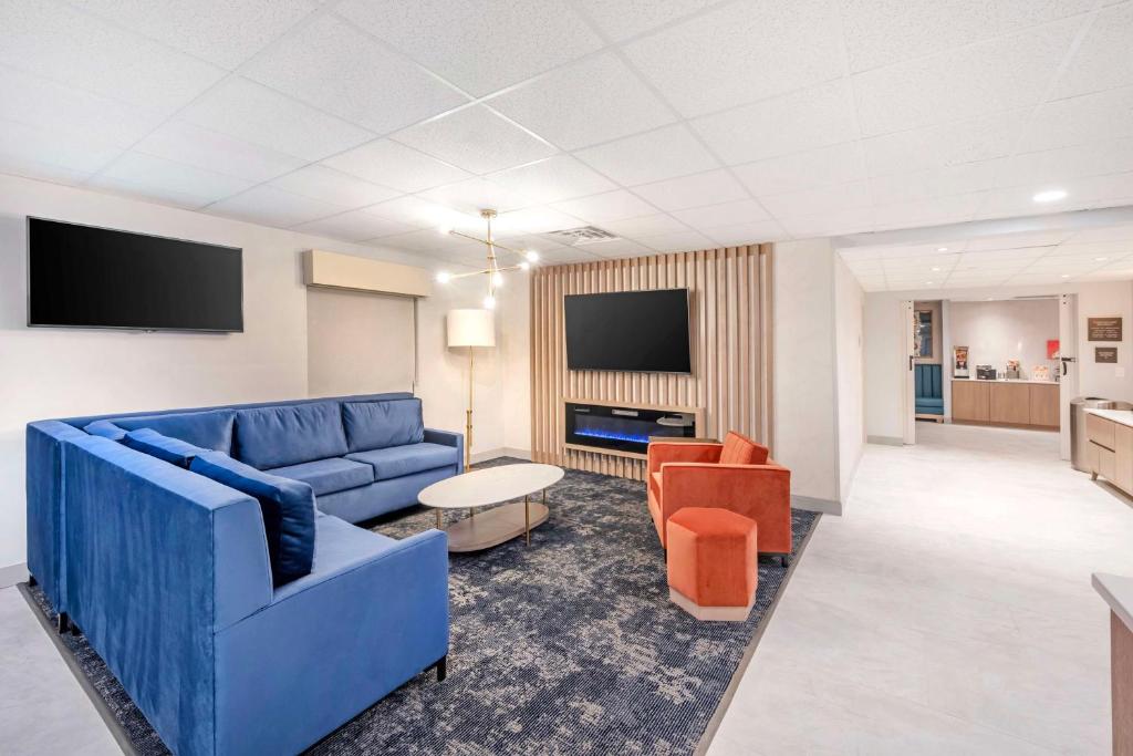 a living room with a blue couch and orange chairs at Best Western River Cities in Ashland