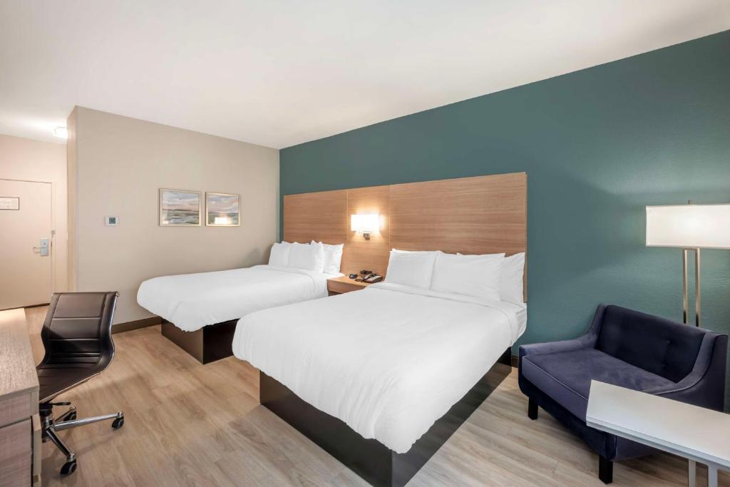 a hotel room with two beds and a chair at Best Western River Cities in Ashland