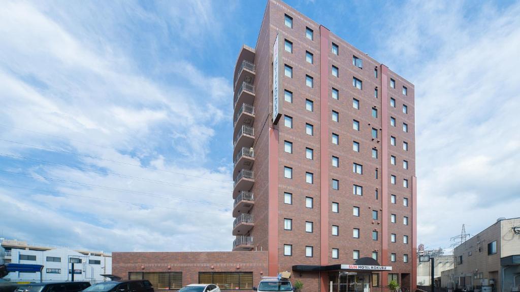 un edificio alto de ladrillo rojo en una ciudad en Sun Hotel Kokubu Kagoshima en Kirishima