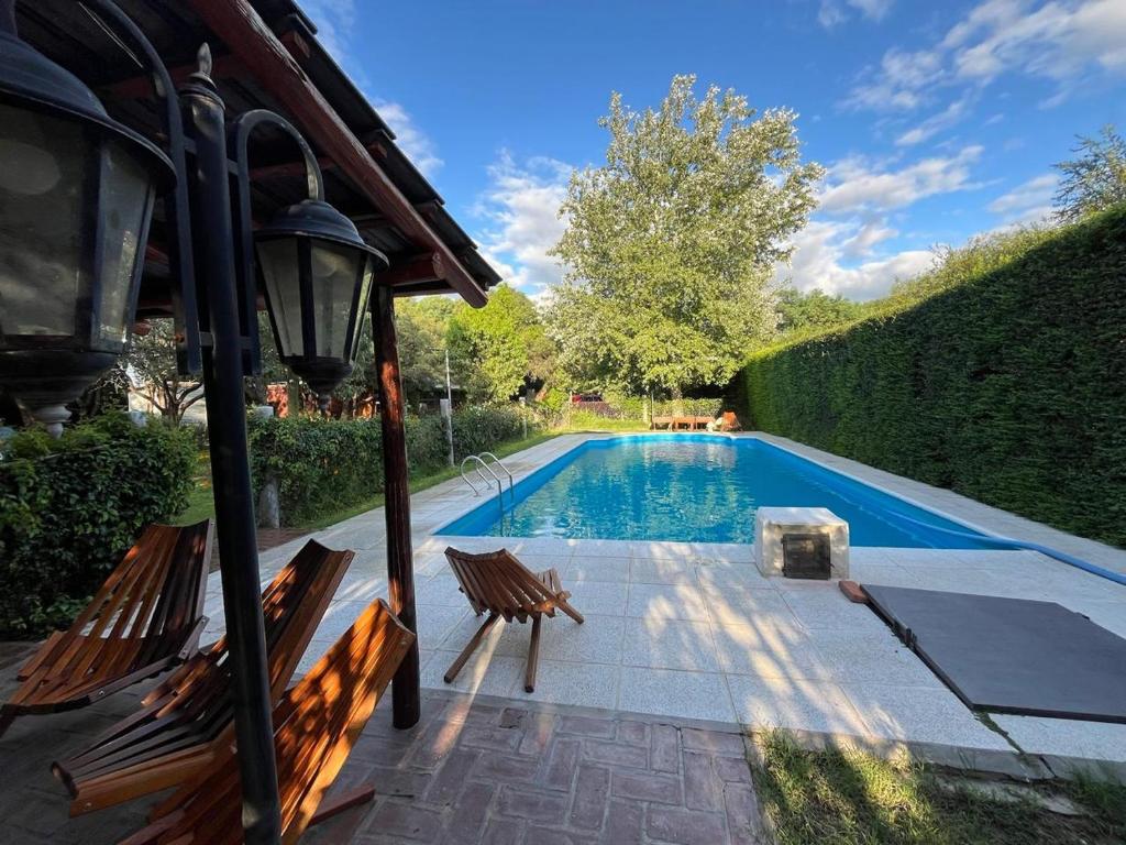 una piscina con 2 sillas y un poste de luz en Cabaña La Huerta "Traslasierra" en Villa Dolores