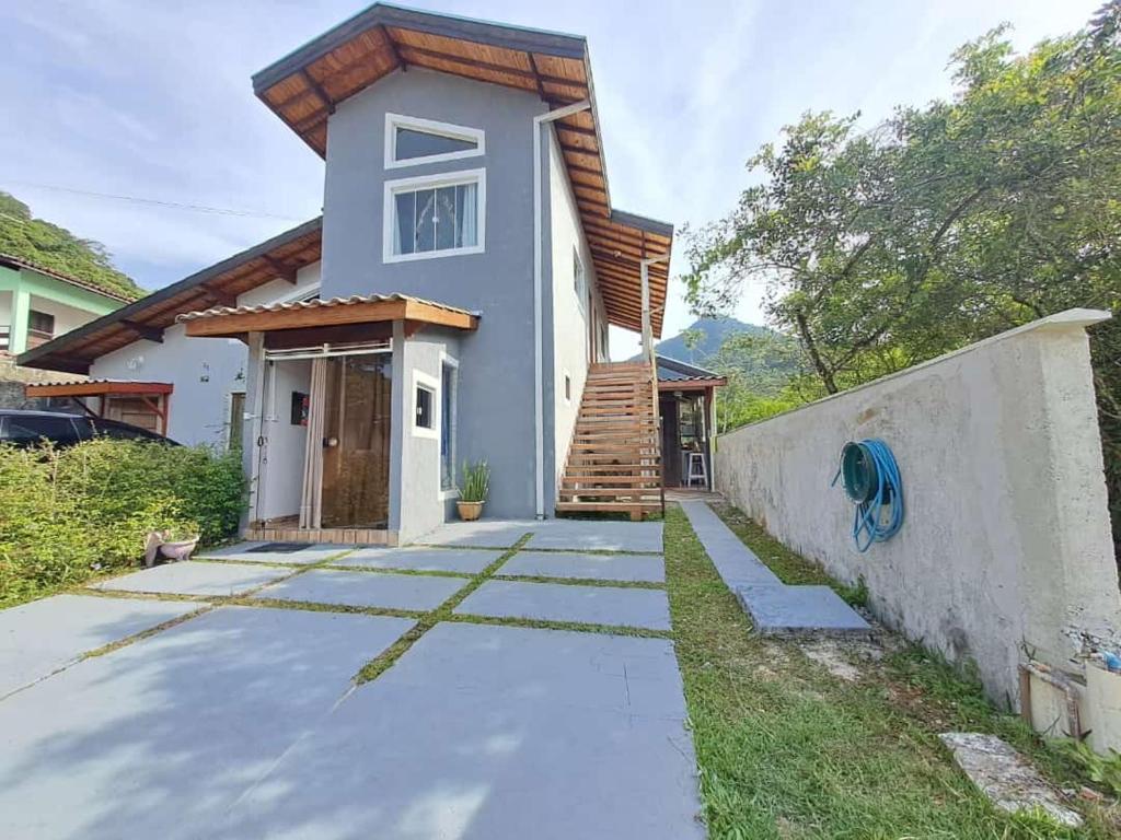 a house with a pathway in front of it at Cantinho do Sol in Caraguatatuba