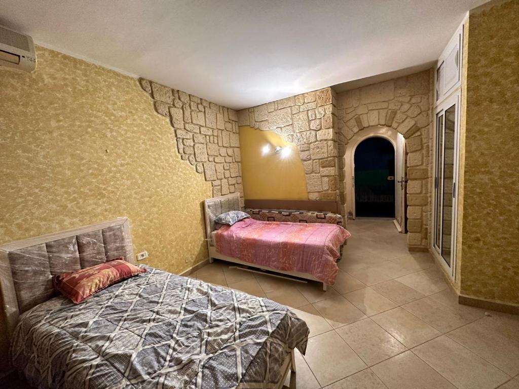 a bedroom with a bed and a stone wall at Studio s0 sousse kantaoui maison de la mer in Port El Kantaoui