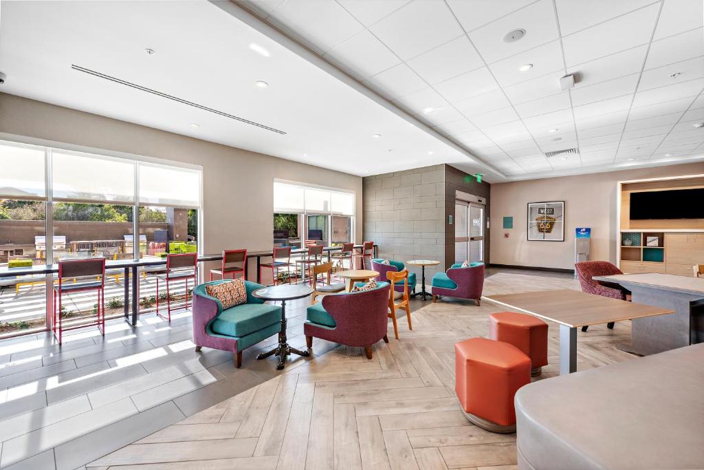 un comedor con mesas, sillas y ventanas en Home2 Suites By Hilton San Bernardino, en San Bernardino
