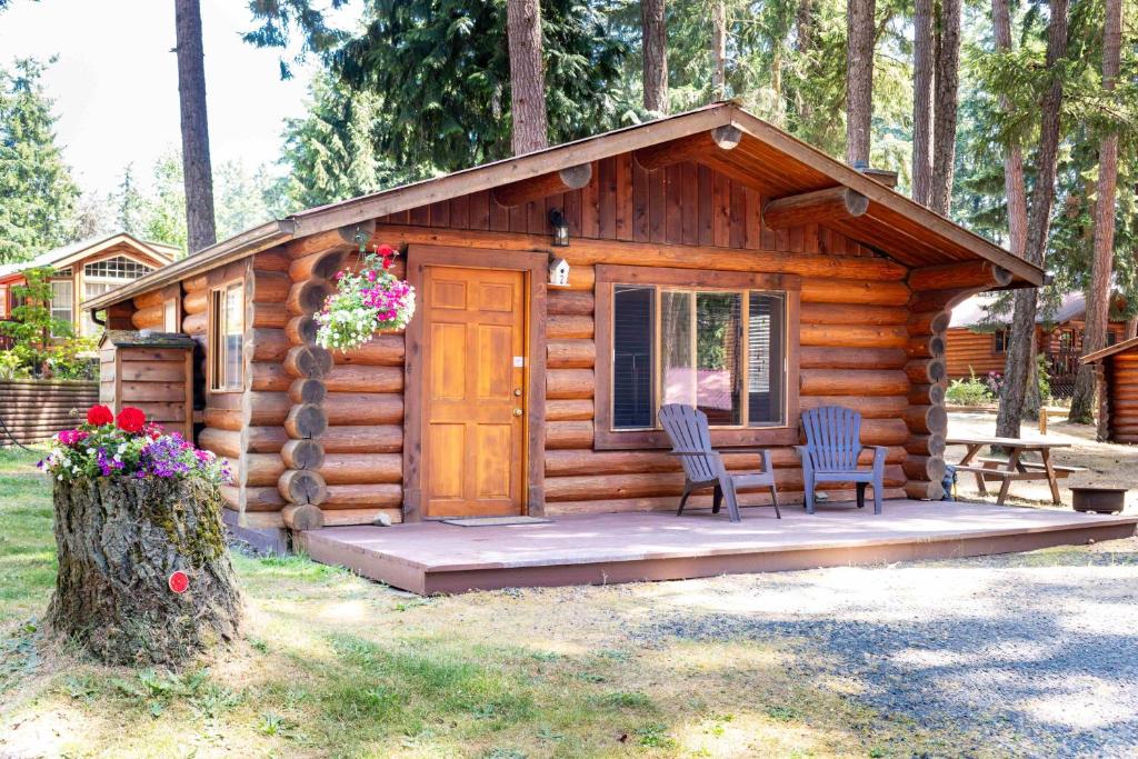 Cabaña de madera con 2 sillas y mesa en Riverbend Cottage & RV Resort, en Parksville