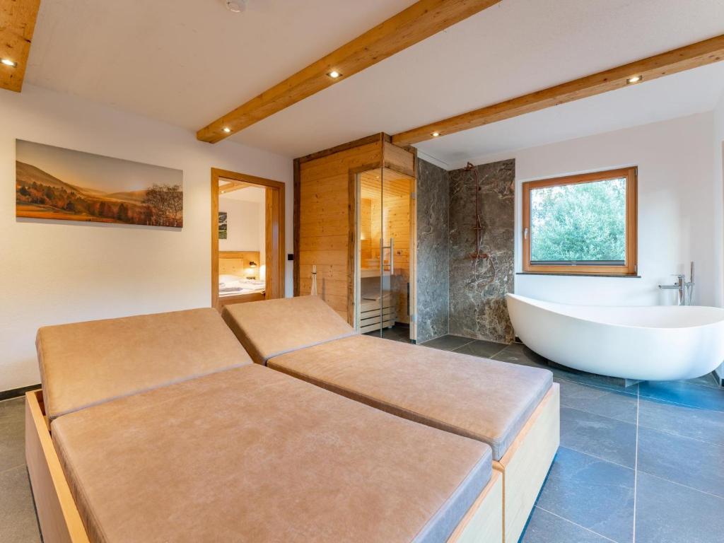 a bathroom with two beds and a bath tub at AlmApARTment Mauterndorf Pichl 7-3 in Mauterndorf