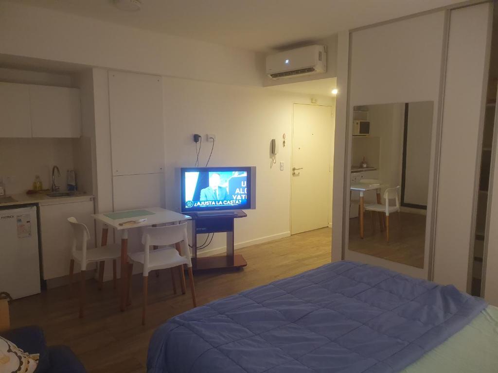 a room with a bed and a table with a television at Cordoba y Florida, Cordoba 618 in Buenos Aires