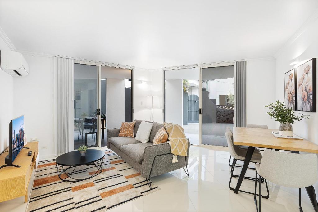 a living room with a couch and a table at Comfy 2-Bed with Pool and Secure Parking in Brisbane