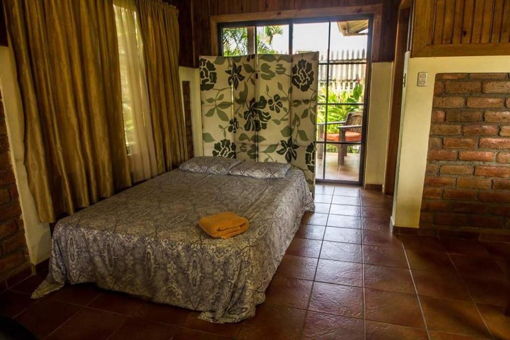 a bedroom with a bed in a room with a window at Cabañas del Mar in Tela