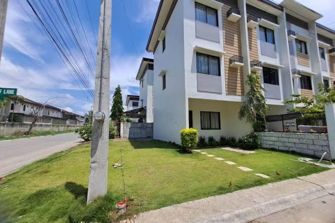 a white house with a lawn in front of it at Cagayan De Oro house in Cagayan de Oro