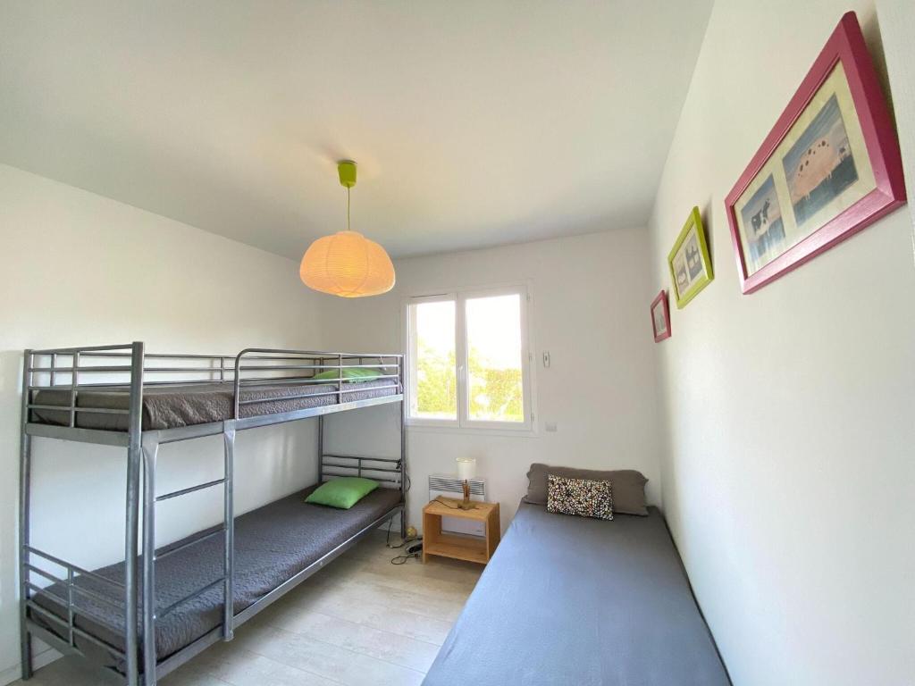 a room with two bunk beds and a window at holiday home, Grayan-et-l&#39;Hôpital in Grayan-et-lʼHôpital