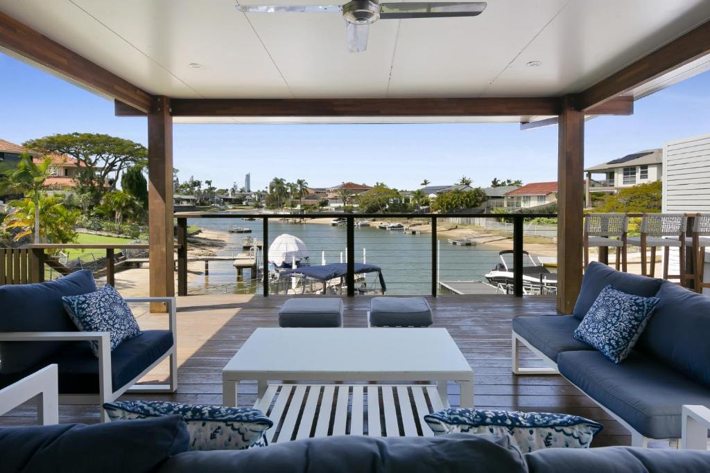 d'une terrasse avec canapés et table et vue sur l'eau. dans l'établissement Magnificent 4-Bed Waterfront With Pool & Views, à Gold Coast