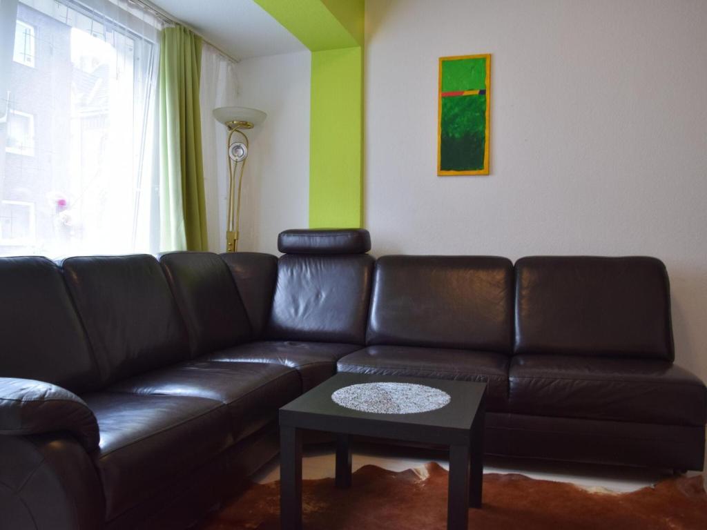 sala de estar con sofá de cuero y mesa en Apartment in Oberhausen near centre, en Oberhausen