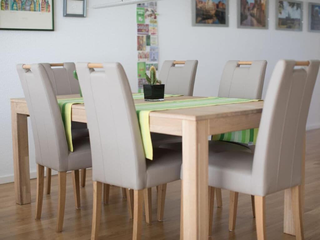 リューネブルクにあるHoliday apartment storage districtのダイニングルームテーブル(椅子付)、木製テーブル(緑のテーブルクロス付)