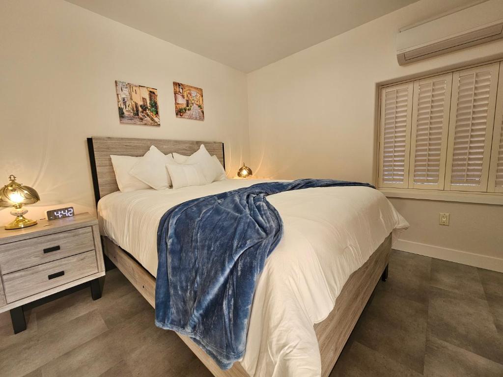 a bedroom with a large bed and a nightstand and a window at La Dolce Vita B and B in Osoyoos