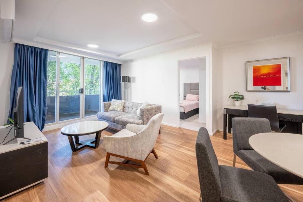 a living room with a couch and a table at Serain Apartment on Northbourne Ave Canberra in Canberra