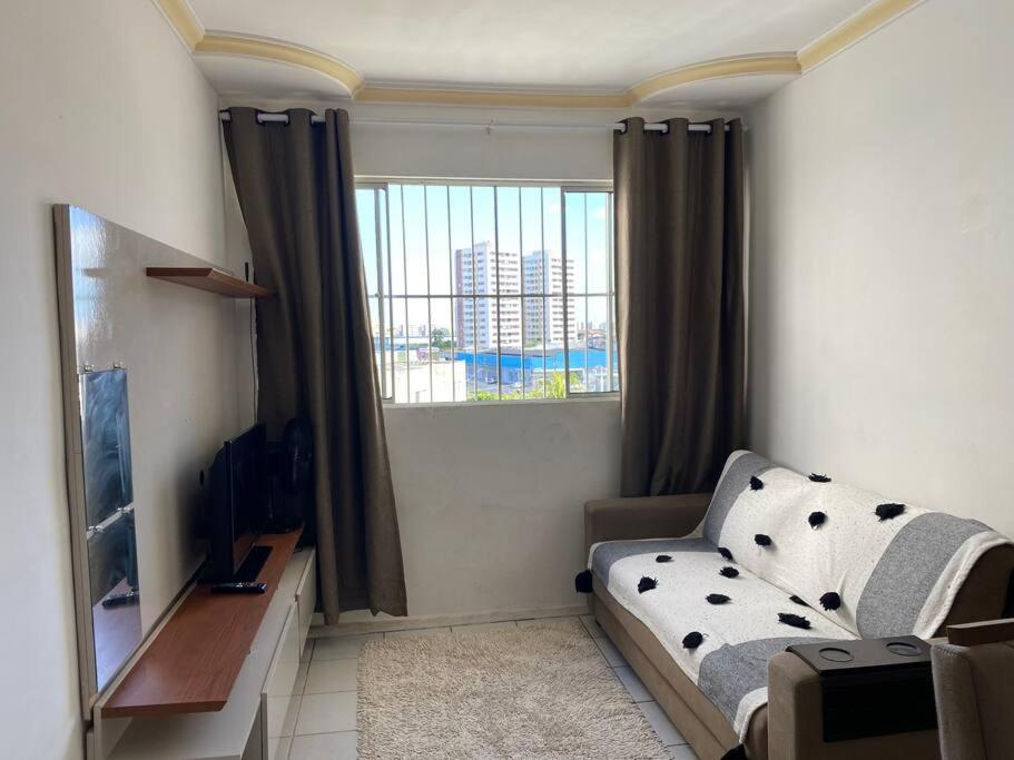 uma sala de estar com um sofá e uma janela em Apt inteiro bem localizado com Wi-Fi e aceita Pets em Aracaju