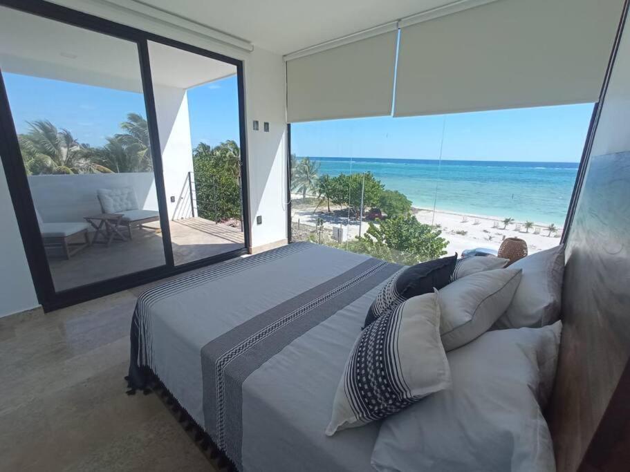 a bedroom with a bed with a view of the beach at Condos Azul Azul Mahahual in Mahahual