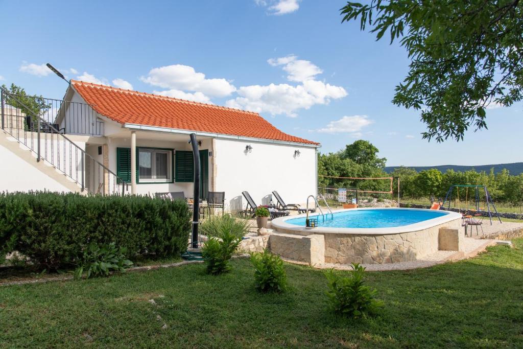a villa with a swimming pool in front of a house at Family friendly house with a swimming pool Veliki Brocanac, Zagora - 22666 in Klis