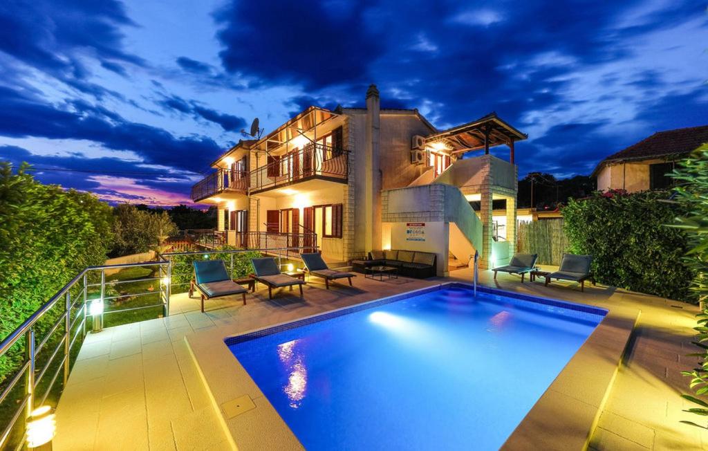 - une piscine en face d'une maison dans l'établissement Family friendly house with a swimming pool Vrsine, Trogir - 22668, à Marina