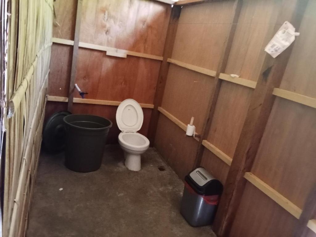 - une petite salle de bains pourvue de toilettes et d'une poubelle dans l'établissement byuk Beya homestay, à Kri