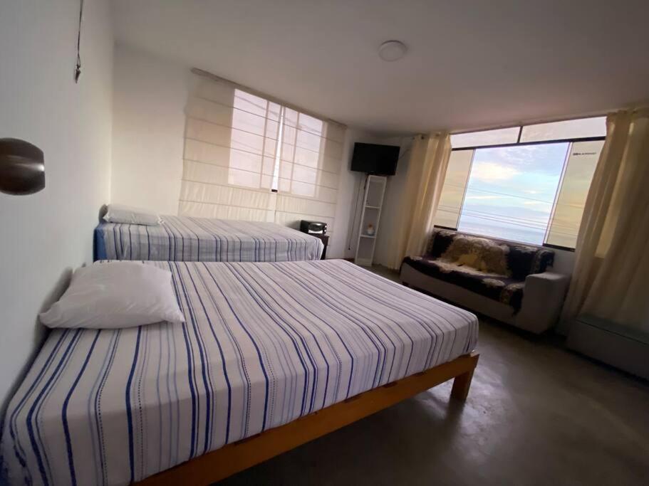 1 dormitorio con 2 camas, sofá y ventana en Habitación y terraza con vista al mar, en Lima