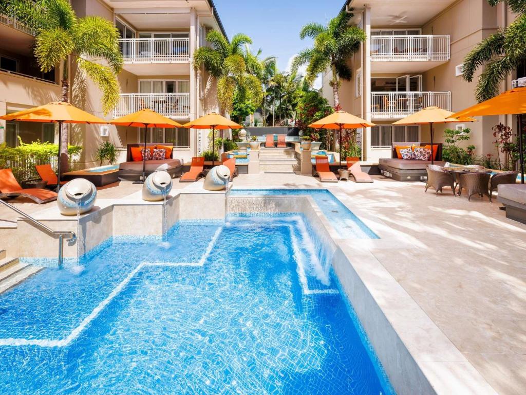 a pool at a hotel with chairs and umbrellas at Laguna on Hastings, Apartment 117, Noosa Heads in Noosa Heads