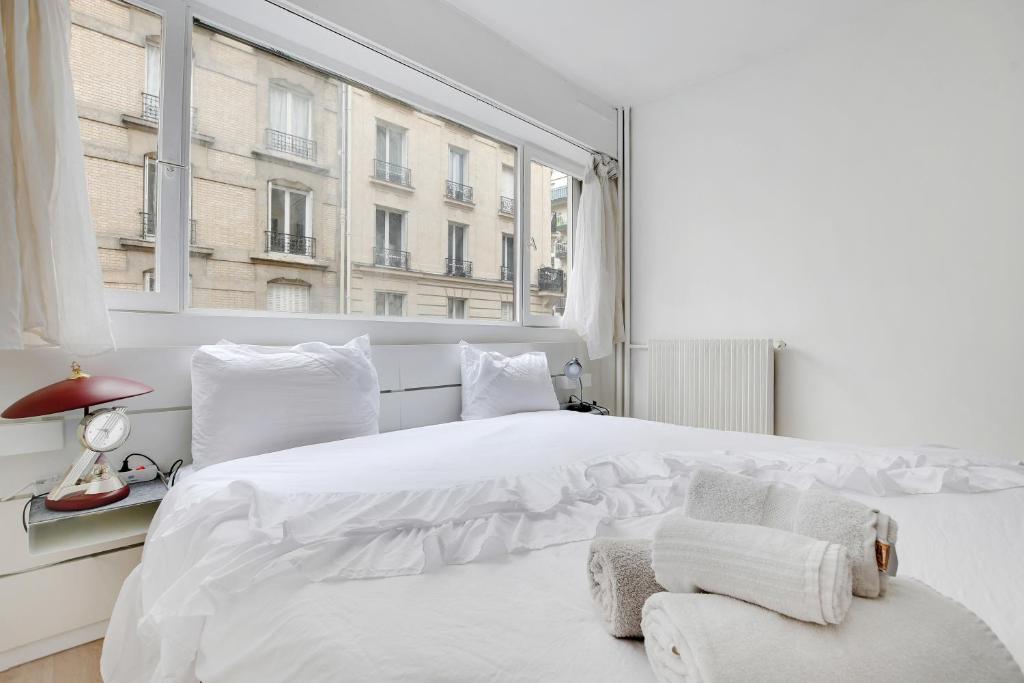 巴黎的住宿－Appartement Alesia，白色的卧室设有一张白色大床和一个窗户。
