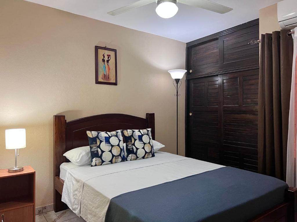 um quarto com uma cama e uma cabeceira em madeira em Casa Cacique Liberia em Liberia