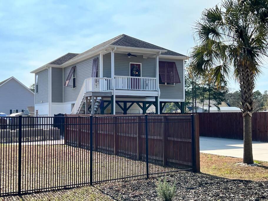 a house with a fence in front of it at Murrels Inlet House Private Heated Saltwater Pool in Myrtle Beach