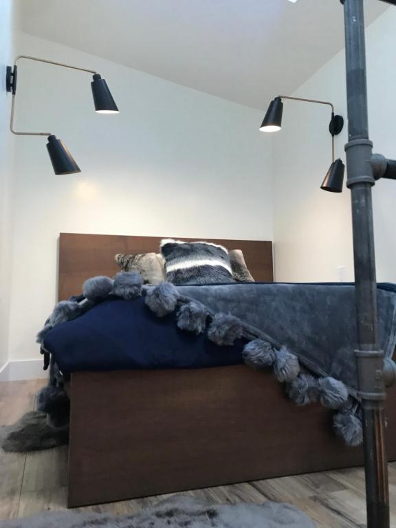 a bedroom with a bed with a blue comforter and lights at Luxury City Tiny House in Denver
