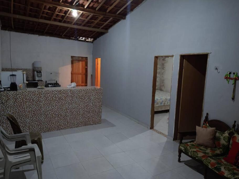 ein Wohnzimmer mit einer Theke und ein Zimmer mit einem Bett in der Unterkunft Casa aconchegante próxima a Praia de Jaguaribe in Itamaracá