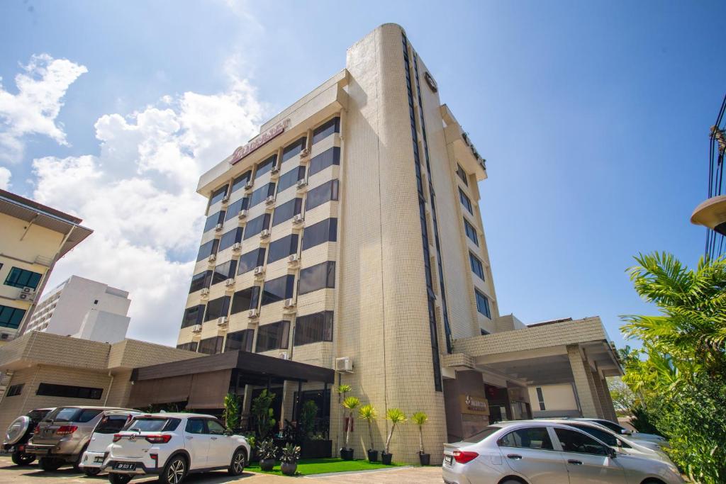 dos coches estacionados frente a un edificio en Somerset Hotel, en Miri